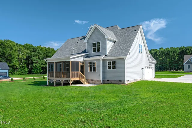 a front view of a house with a yard and green space