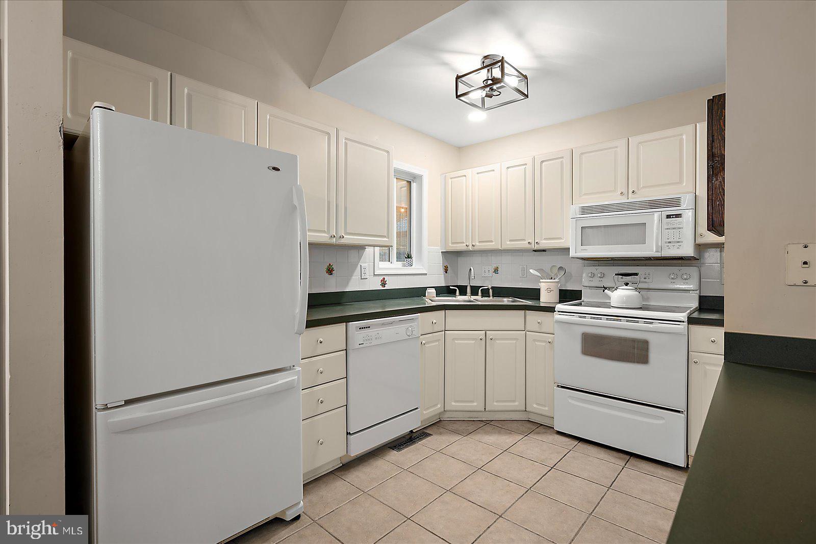 74 Robin Hood Trail Ocean Pines, MD 21811 - Photo 17 of 59 a kitchen with white cabinets and white appliances