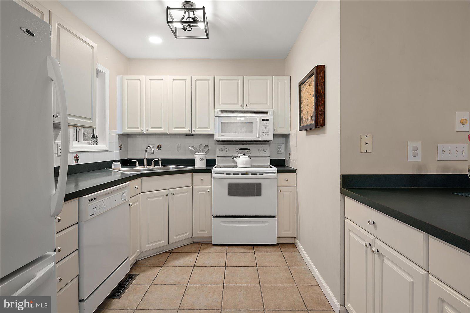 74 Robin Hood Trail Ocean Pines, MD 21811 - Photo 18 of 59 a kitchen with a white cabinets and white appliances