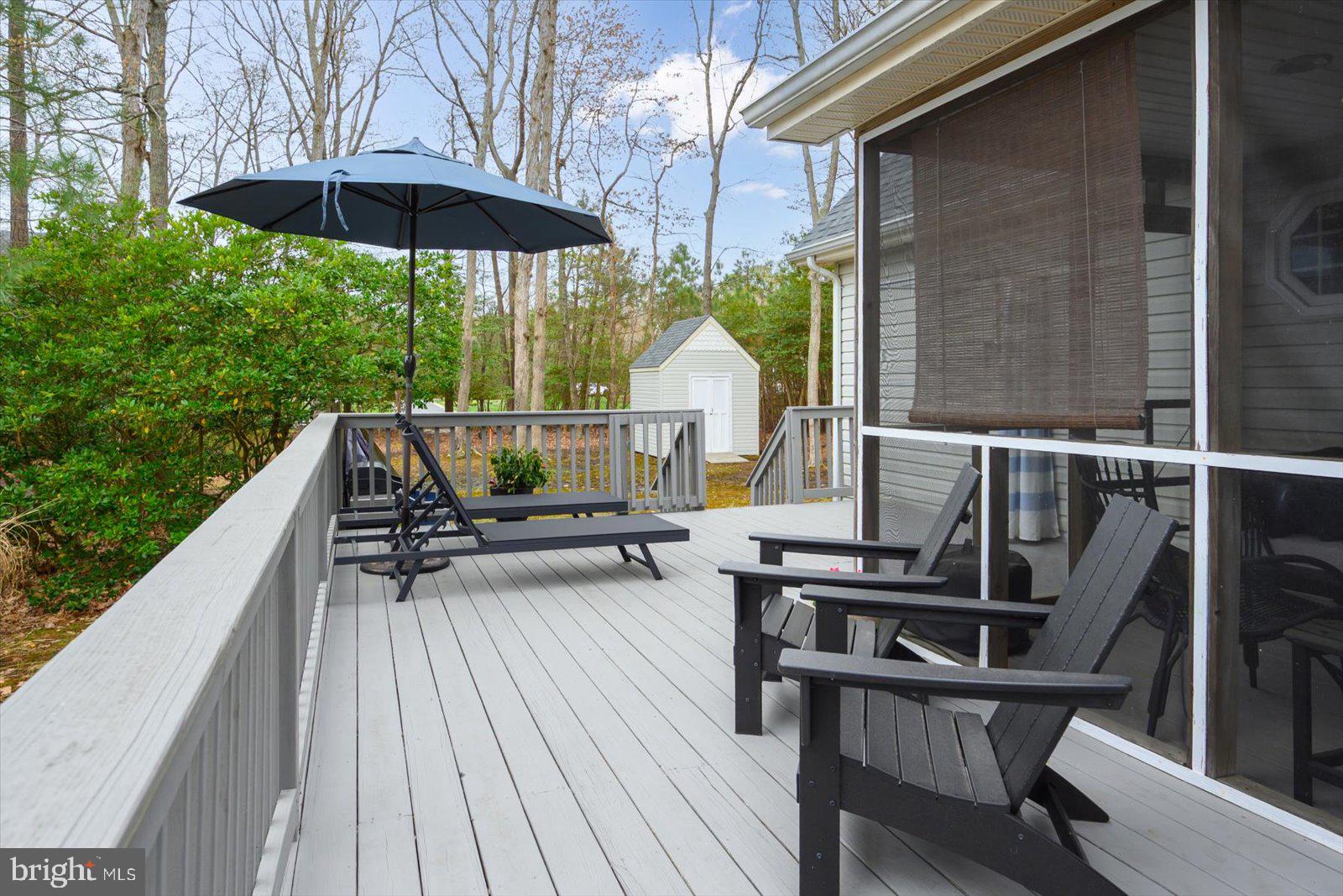 74 Robin Hood Trail Ocean Pines, MD 21811 - Photo 51 of 59 a view of deck with table and chairs under an umbrella with wooden floor