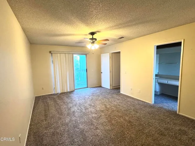 a view of a big room with windows and chandelier fan