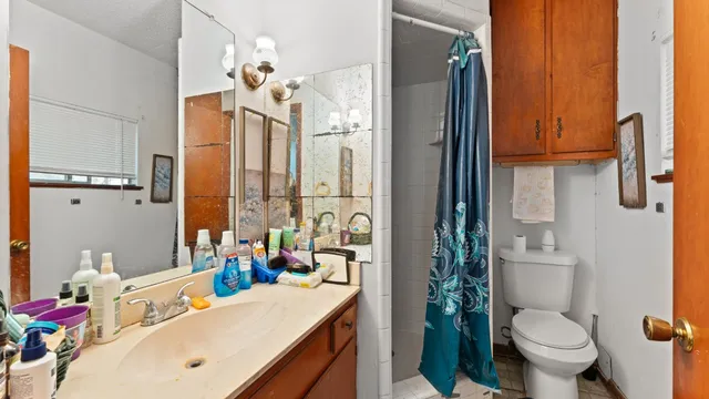 a bathroom with a sink vanity mirror and toilet