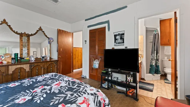 a bedroom with a bed and flat screen tv