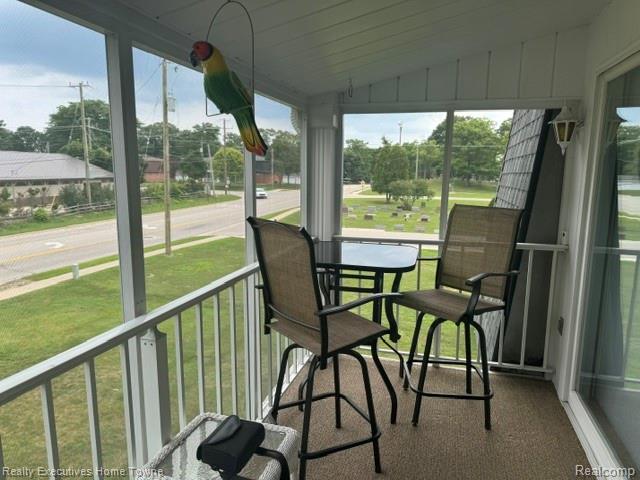 1467 Krafft Road, Unit 8 Port Huron, MI 48060 - Photo 23 of 28 Screened porch featuring a textured floor, white railing, and exterior wall light fixture
