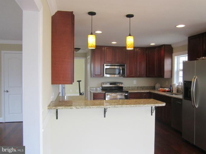 2107 Rolling Rd. Windsor Mill, MD 21244 - Photo 2 of 29 a kitchen with stainless steel appliances granite countertop a sink refrigerator and microwave