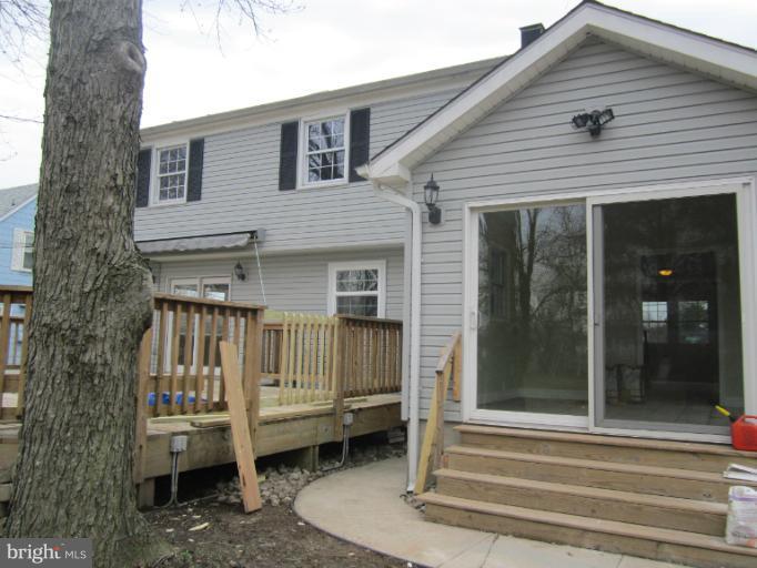 2107 Rolling Rd. Windsor Mill, MD 21244 - Photo 28 of 29 a view of a house with a small deck and a large tree