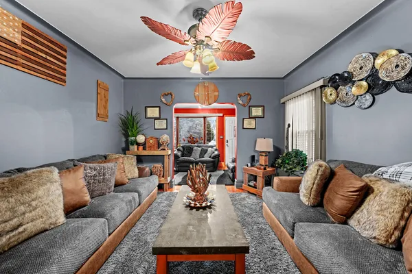 a living room with furniture kitchen view and a chandelier