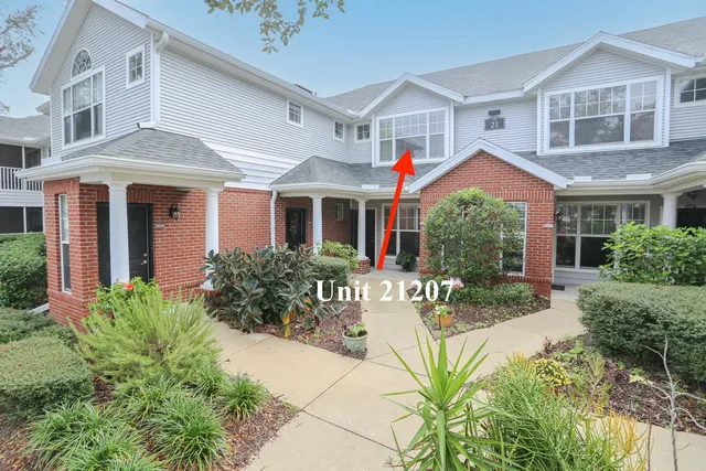 a view of a brick house with many windows and plants