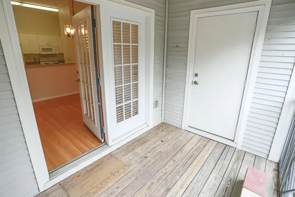 a view of a hallway with wooden floor and a bathroom