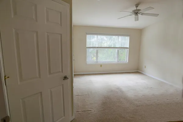an empty room with windows and cabinet
