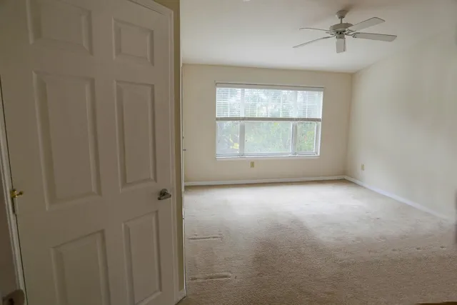 an empty room with windows and cabinet