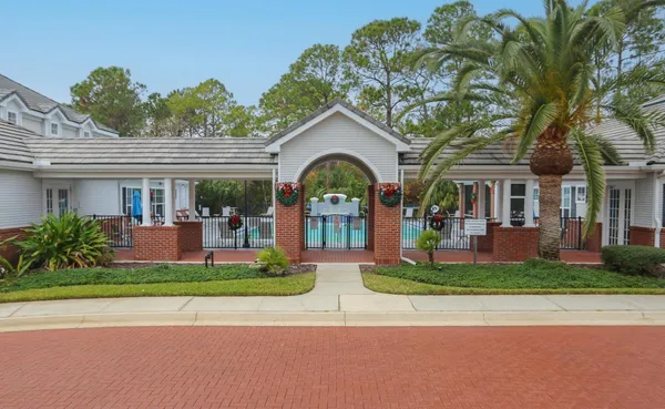 a view of a white house with a large windows and plants