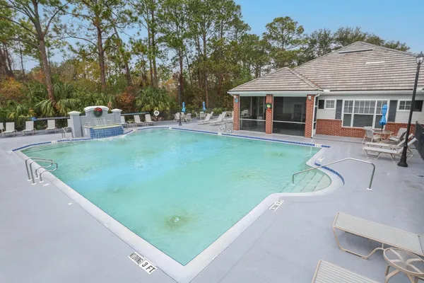 a front view of a house with a garden and lake view