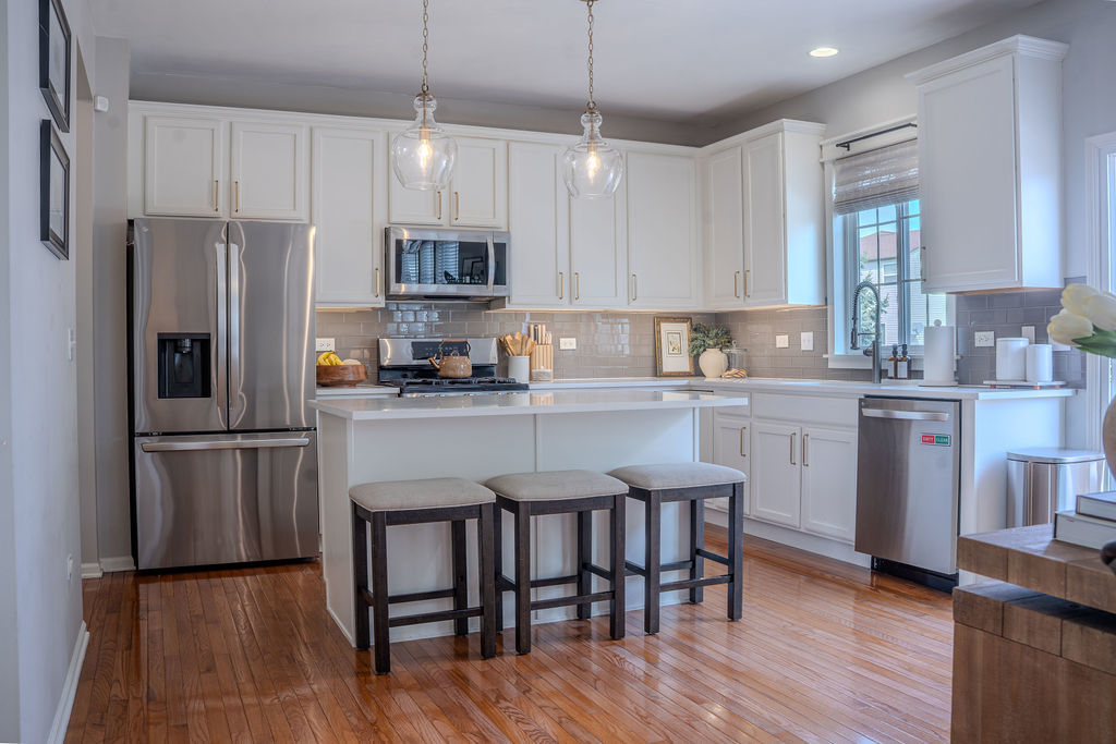 250 Tiger Street Bolingbrook, IL 60490 - Photo 8 of 36 a kitchen with refrigerator cabinets dining table and chairs