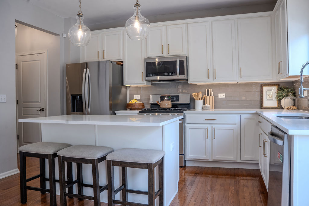 250 Tiger Street Bolingbrook, IL 60490 - Photo 9 of 36 a kitchen with stainless steel appliances granite countertop a refrigerator a sink dishwasher a stove and white cabinets with wooden floor