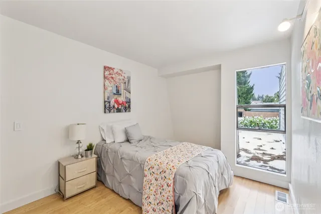 a bedroom with bed and wooden floor