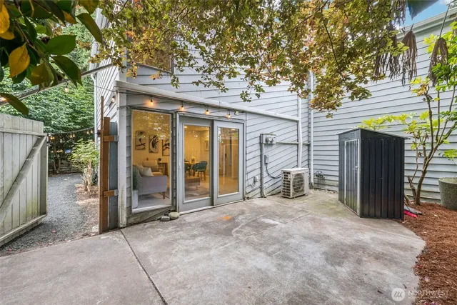 a view of a house with large windows and a large tree