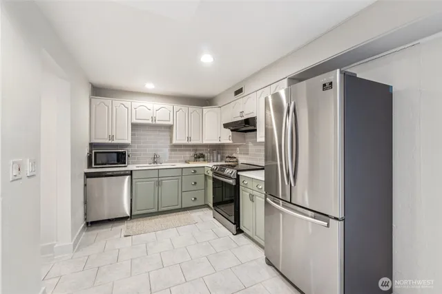 a kitchen with stainless steel appliances granite countertop a refrigerator sink and stove