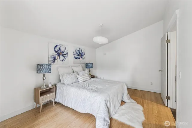a bedroom with a bed and a table with wooden floor