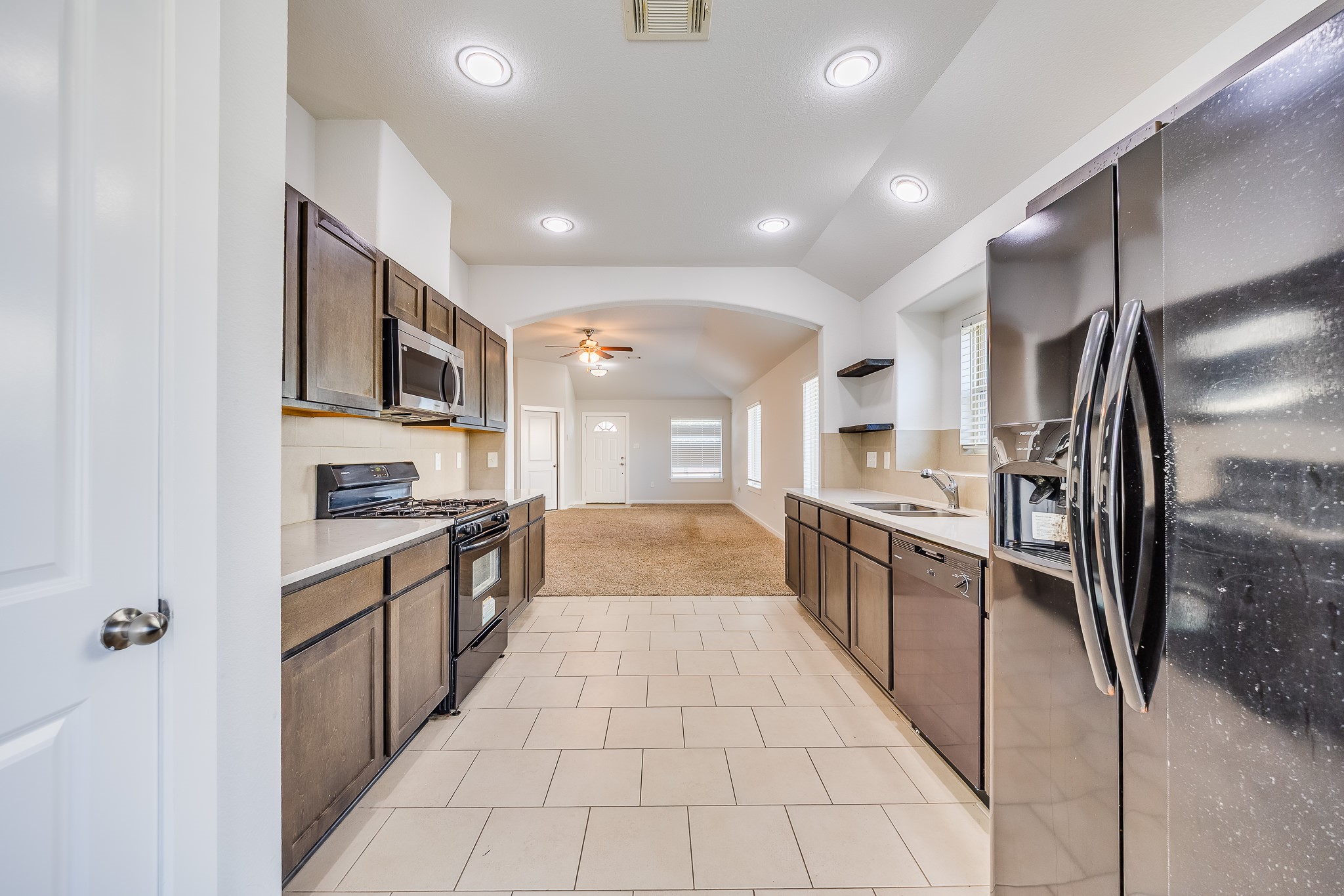 6807 Alamitos Court Rosharon, TX 77583 - Photo 11 of 34 Open kitchen flowing into the living room, creating a spacious, inviting area perfect for entertaining and family gatherings.