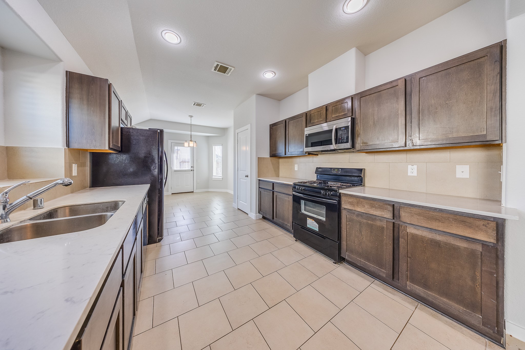6807 Alamitos Court Rosharon, TX 77583 - Photo 14 of 34 Open-concept kitchen seamlessly connecting to the dining room, ideal for entertaining, family meals, and effortless daily living.