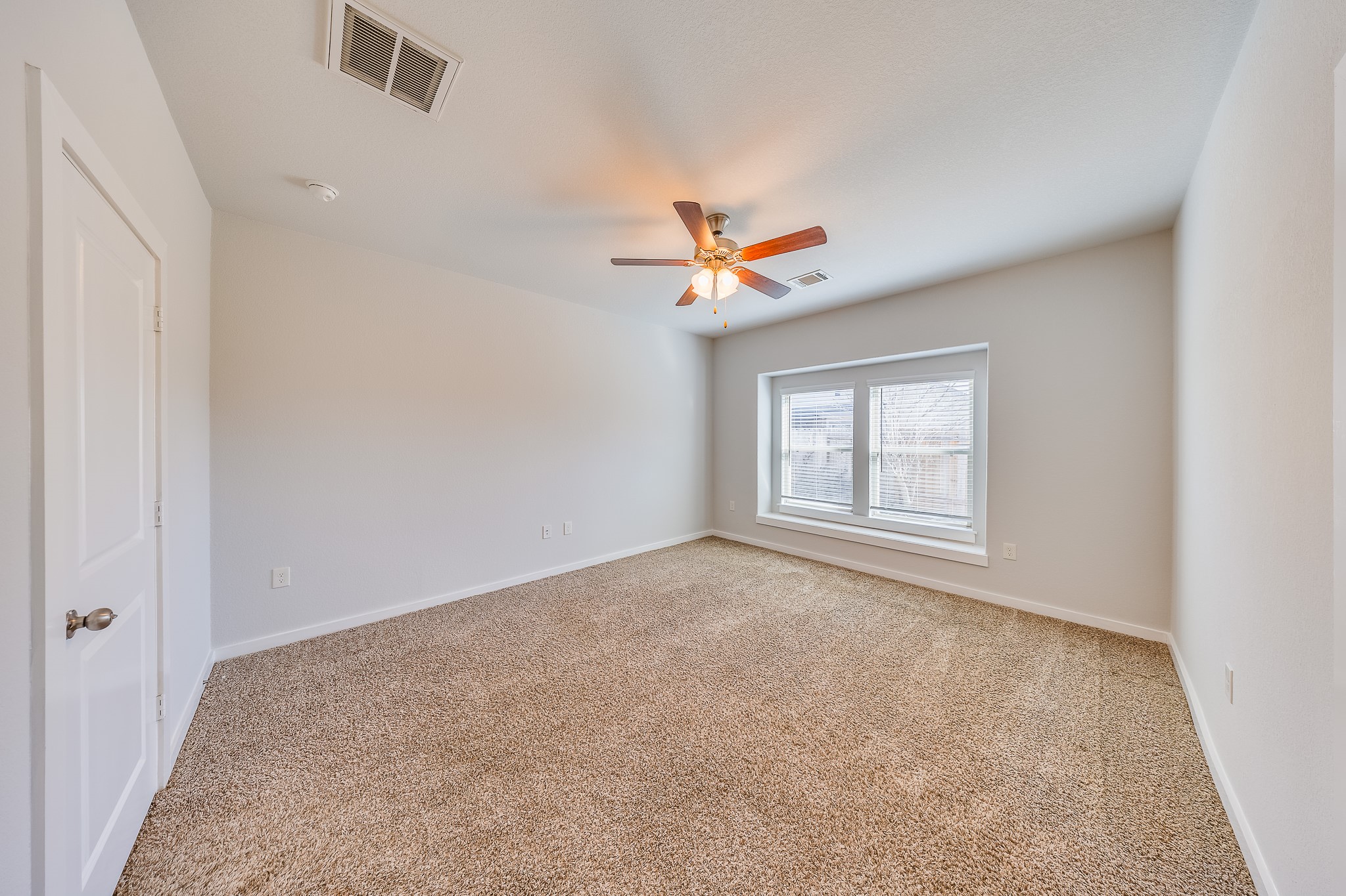 6807 Alamitos Court Rosharon, TX 77583 - Photo 21 of 34 Bedroom 2 filled with natural light from large windows, creating a bright, airy, and welcoming atmosphere.