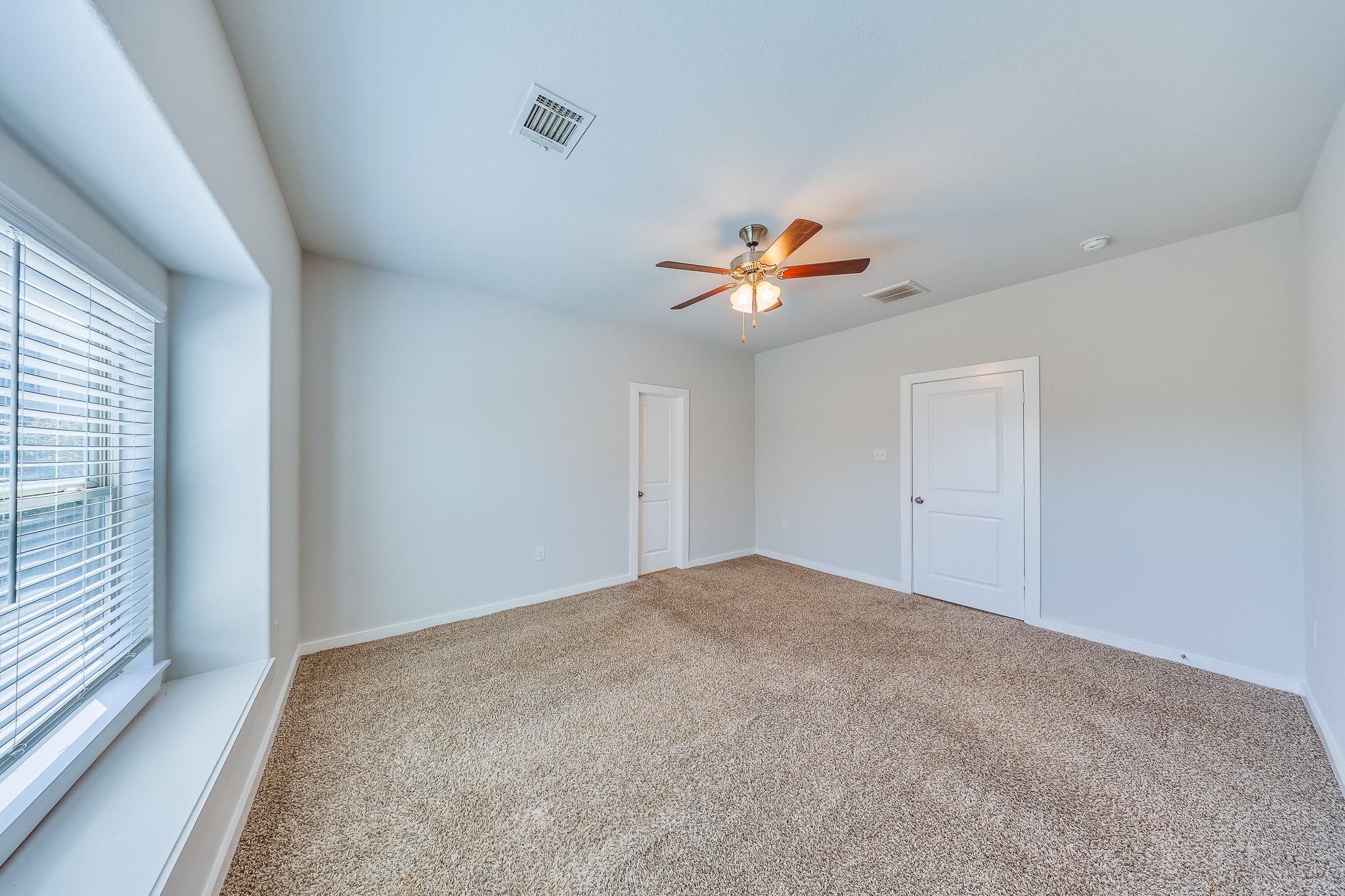6807 Alamitos Court Rosharon, TX 77583 - Photo 22 of 34 Bedroom 2 filled with natural light from large windows, creating a bright, airy, and welcoming atmosphere.