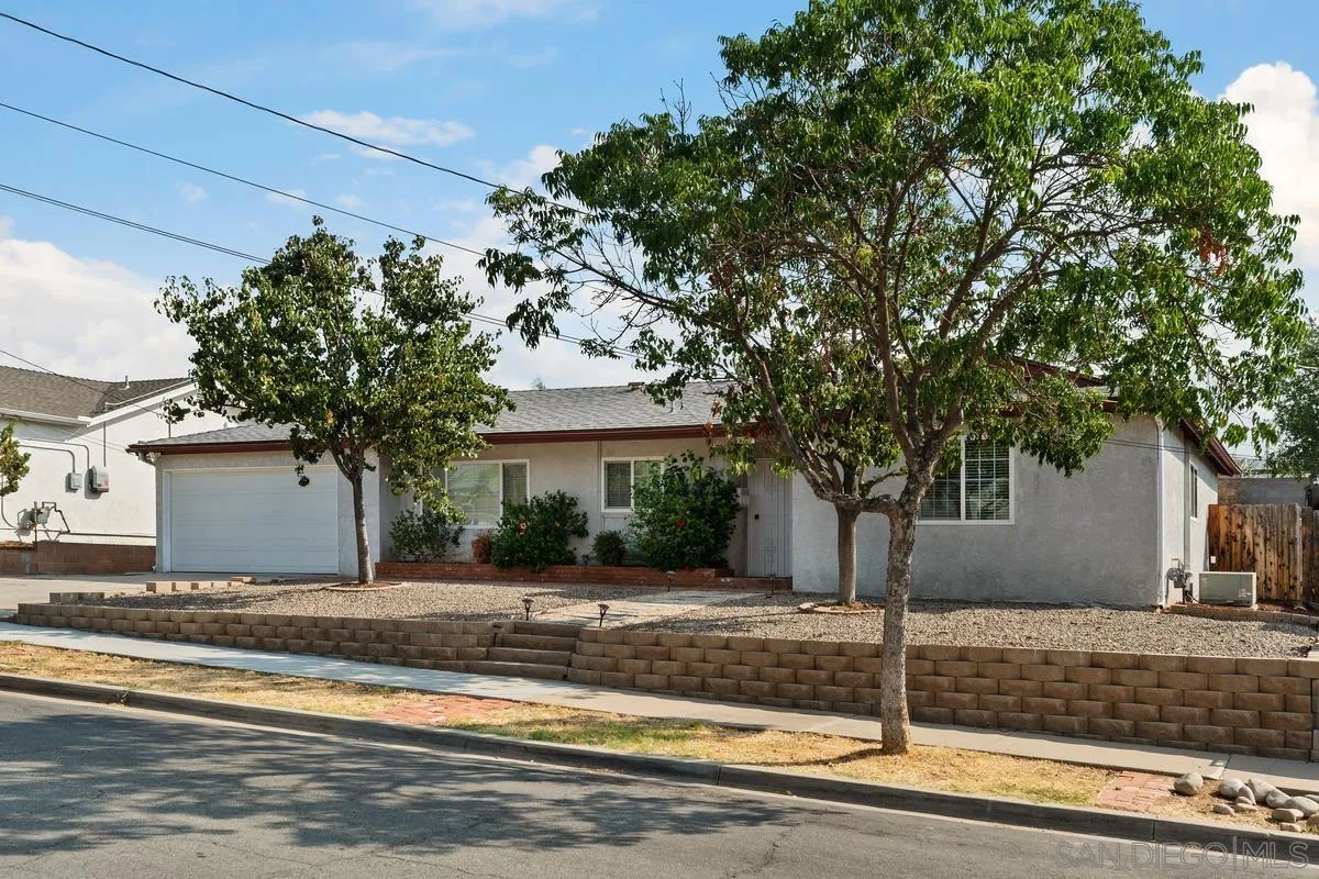 a front view of a house with a tree