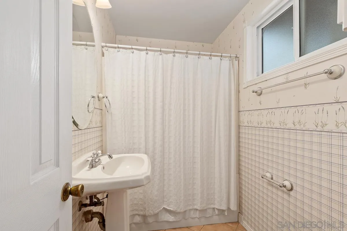 9343 Oakbourne Road Santee, CA 92071 - Photo 12 of 19 a bathroom with a sink a mirror and a shower curtain