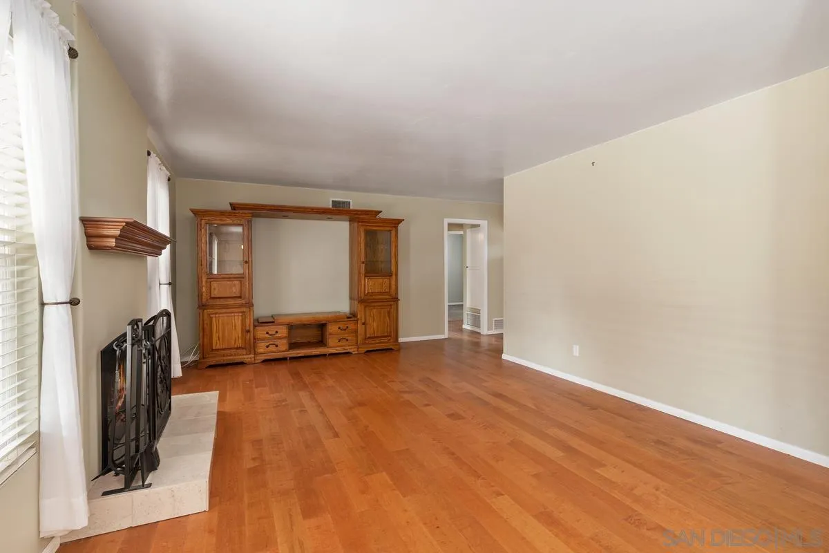 9343 Oakbourne Road Santee, CA 92071 - Photo 3 of 19 a view of a livingroom with a fireplace and a window