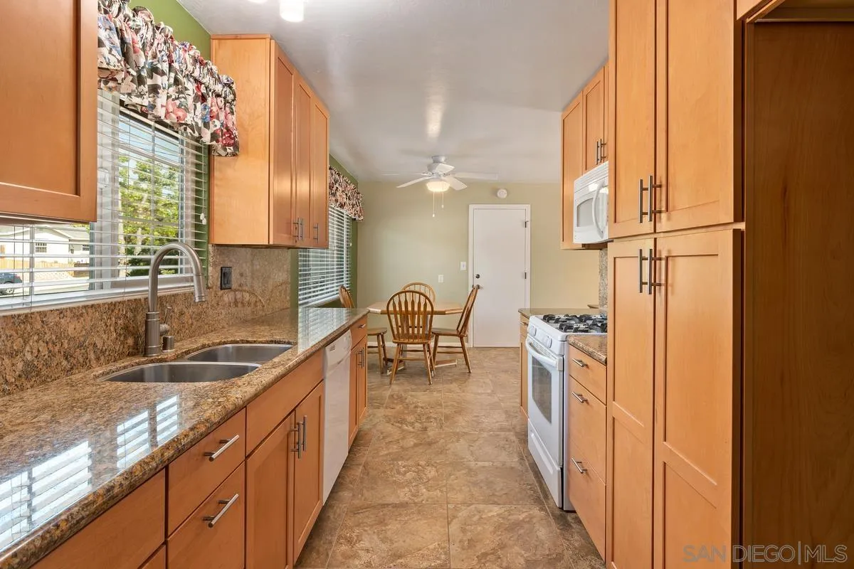 9343 Oakbourne Road Santee, CA 92071 - Photo 8 of 19 a kitchen with granite countertop a sink and a refrigerator