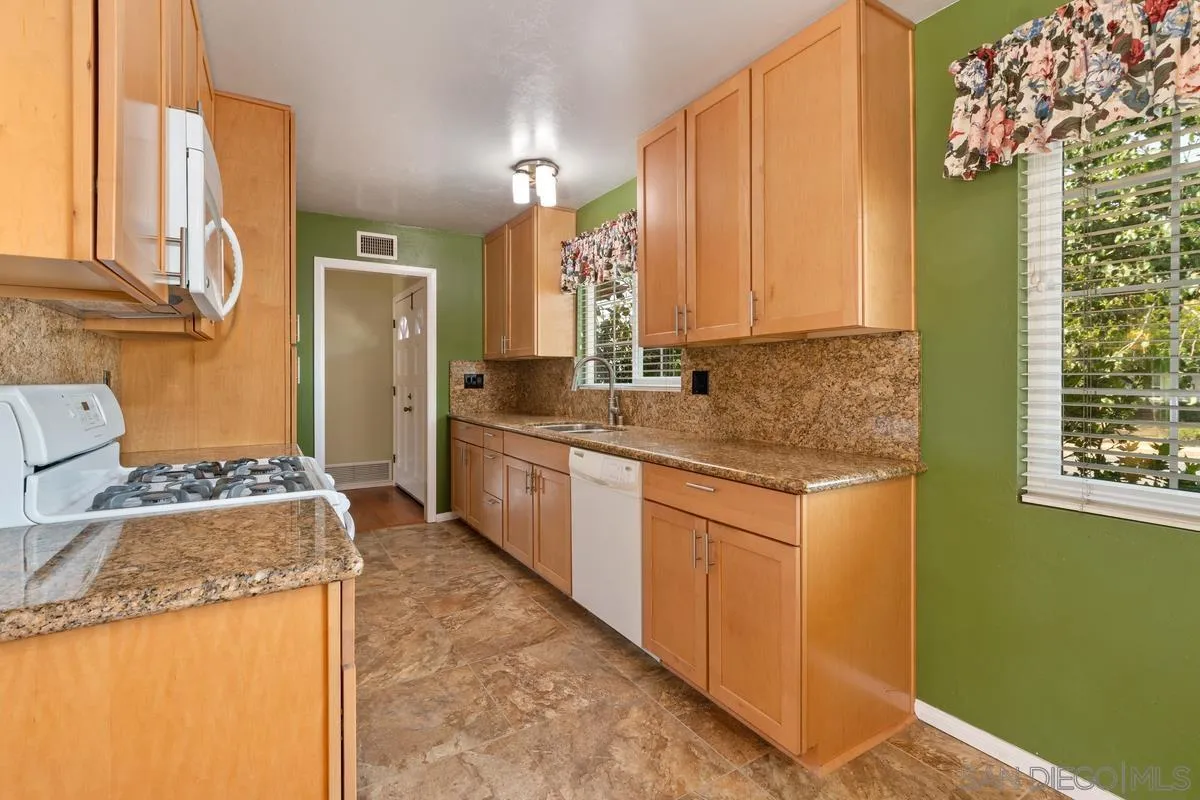 9343 Oakbourne Road Santee, CA 92071 - Photo 9 of 19 a kitchen with stainless steel appliances granite countertop a sink stove and refrigerator