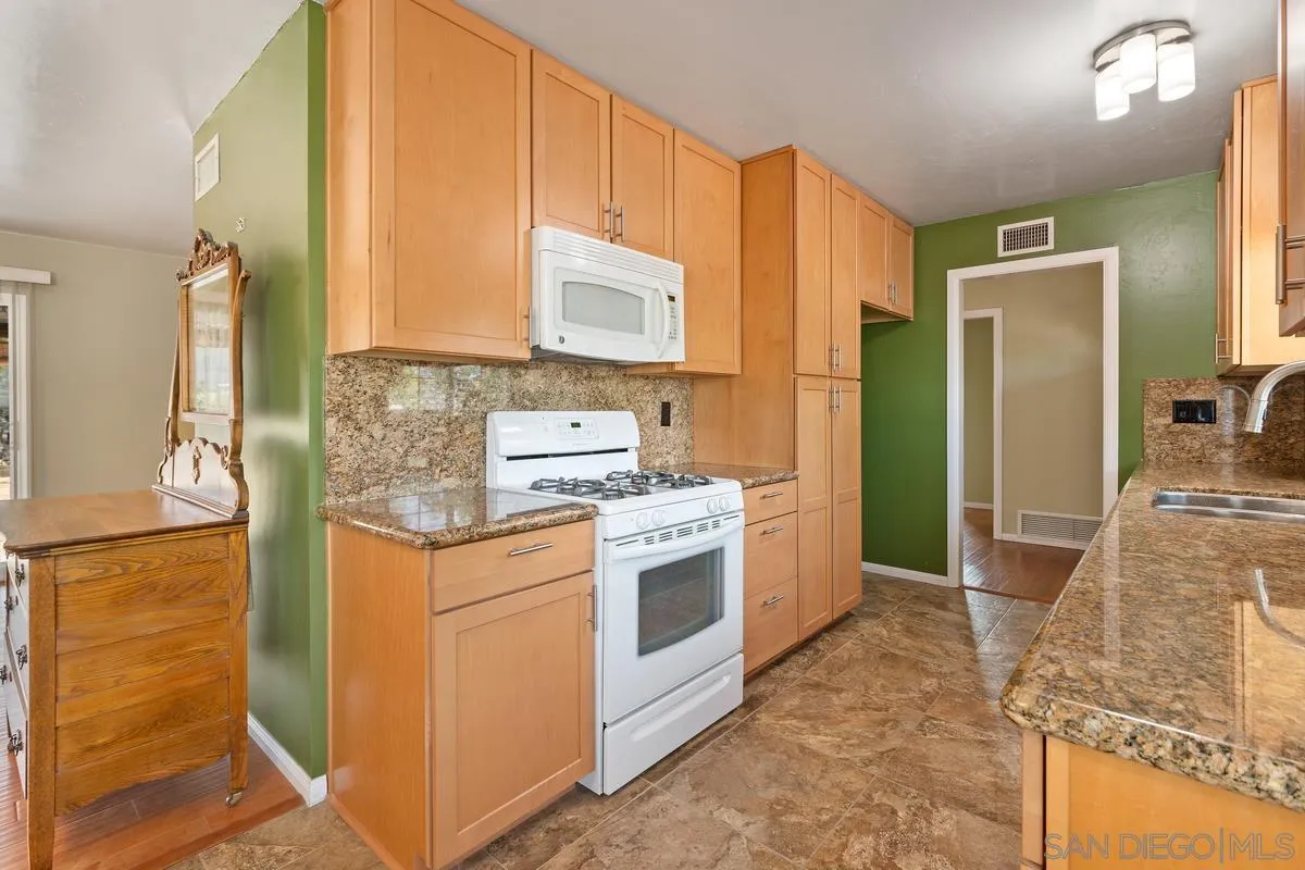 9343 Oakbourne Road Santee, CA 92071 - Photo 10 of 19 a kitchen with stainless steel appliances granite countertop a stove a refrigerator and a sink