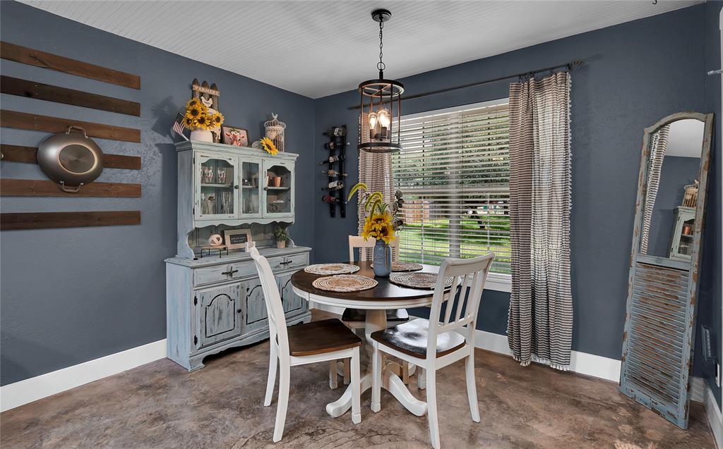 37 Bluebonnet Loop Morgan's Point Resort, TX 76513 - Photo 15 of 38 Dining area featuring a contemporary chandelier, large window with blinds, and durable concrete flooring