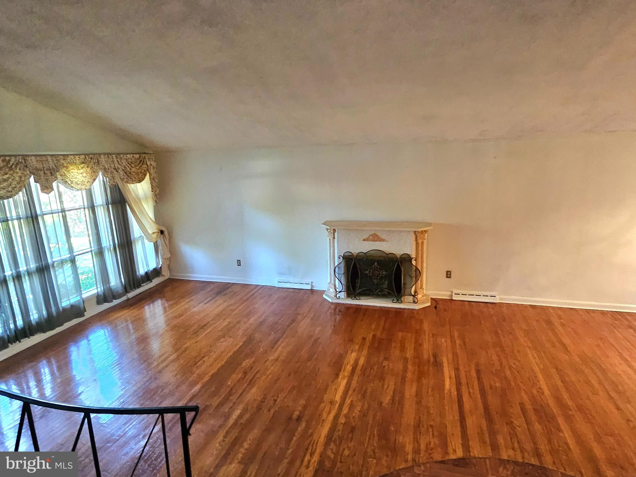 148 Church Road Elkins Park, PA 19027 - Photo 4 of 33 a view of empty room with wooden floor and fireplace