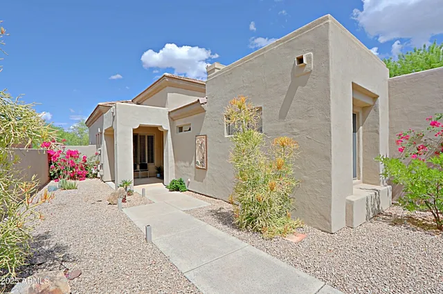 a front view of a house with a yard and potted plants