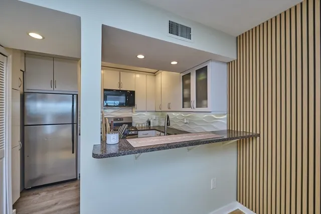 a kitchen with refrigerator and microwave