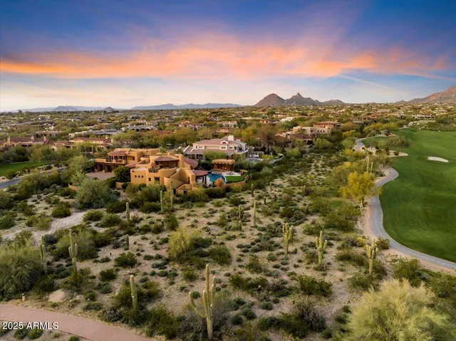 an aerial view of residential houses with outdoor space and trees