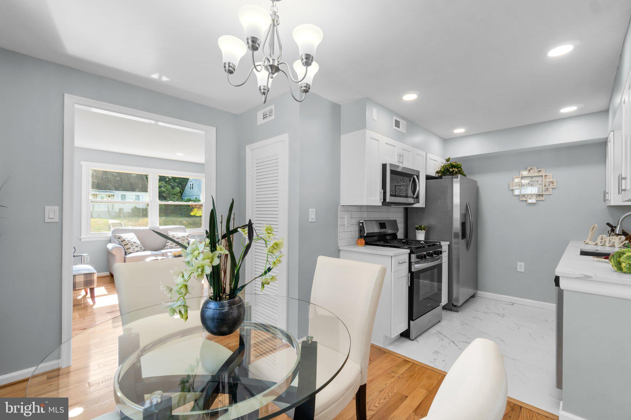 722 Templecliff Road Pikesville, MD 21208 - Photo 7 of 30 a view of a dining room with furniture a kitchen and chandelier