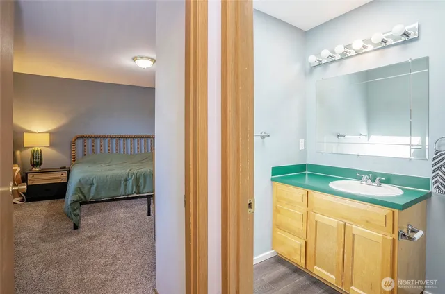 a bathroom with a granite countertop toilet sink and mirror
