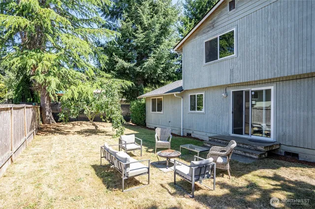 a view of backyard of house with outdoor seating