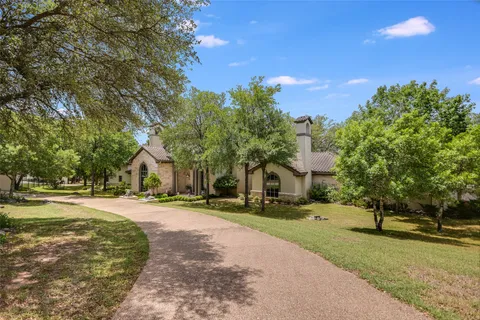 a front view of a house with a yard and trees