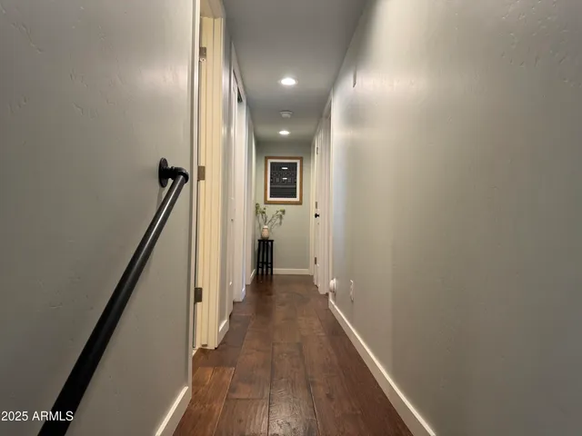 a view of a hallway with wooden floor and staircase