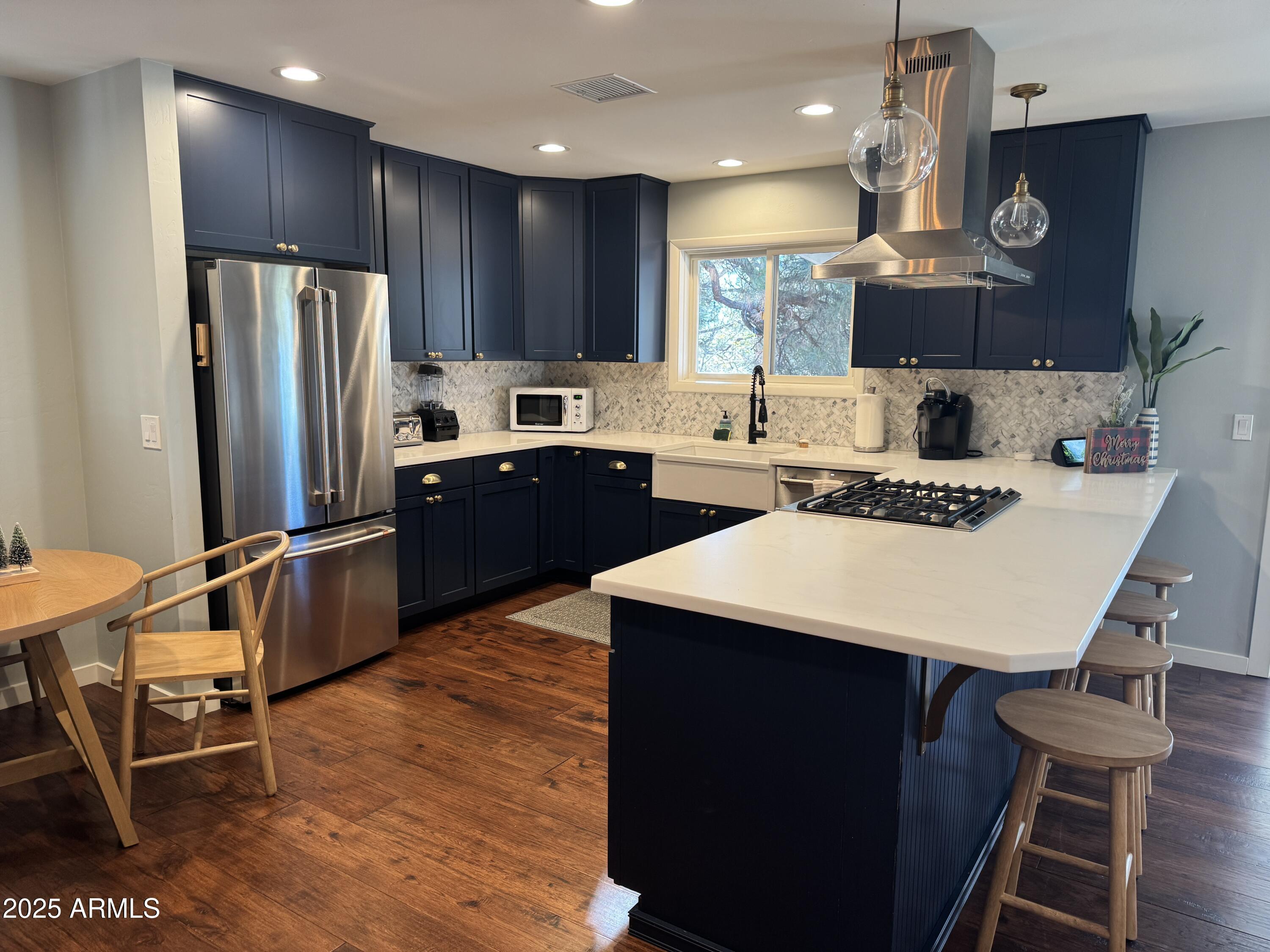 1675 East Appalachian Road Flagstaff, AZ 86004 - Photo 10 of 26 a kitchen with stainless steel appliances kitchen island granite countertop a sink a stove a refrigerator cabinets and chairs