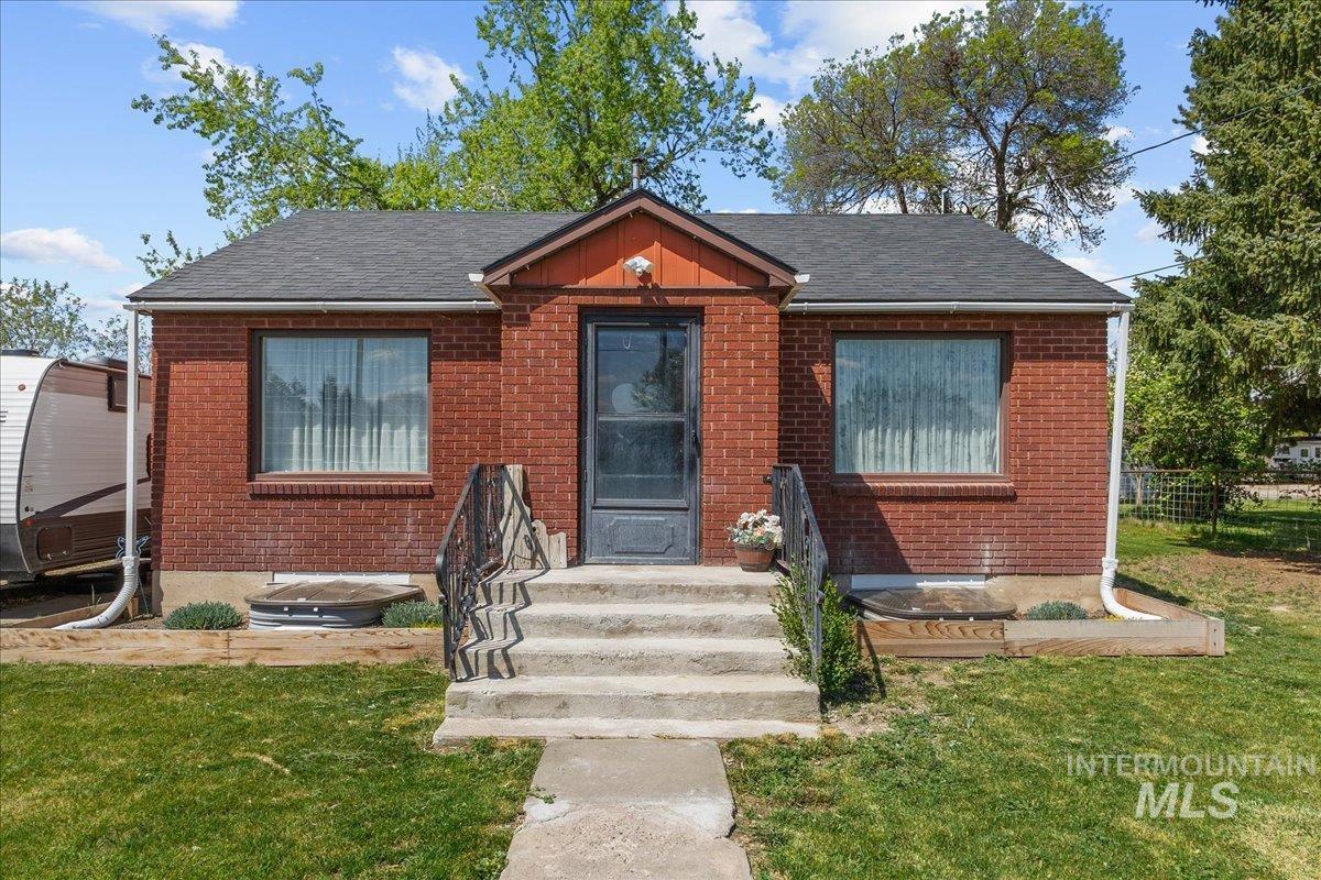 1958 East 1775 South Gooding, ID 83330 - Photo 4 of 49 Brick exterior with a dark shingle roof and a concrete porch