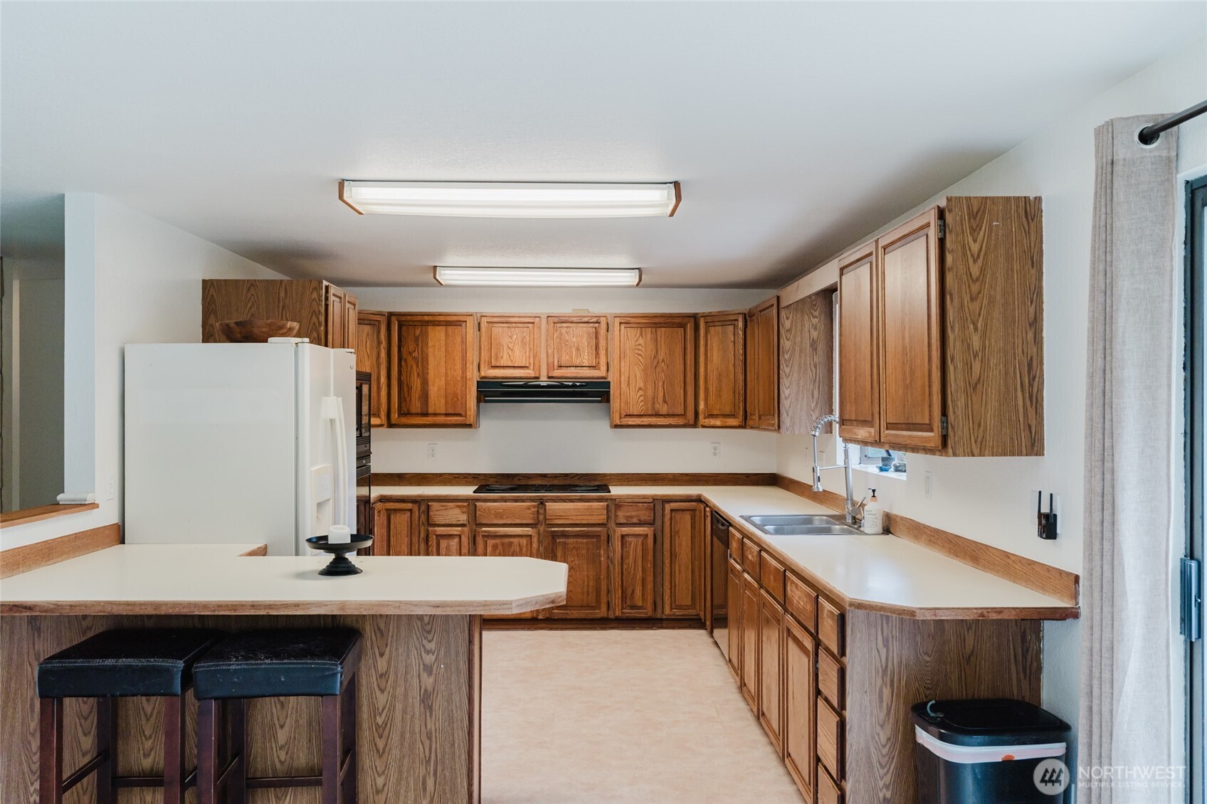 41 Meadowood Drive Elma, WA 98541 - Photo 11 of 40 a kitchen with a sink a refrigerator and wooden cabinets