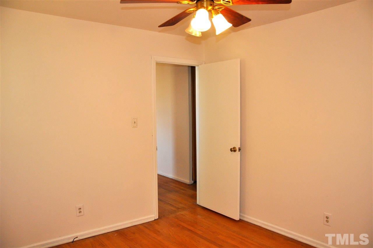 819 Hadley Road Raleigh, NC 27610 - Photo 13 of 20 an empty room with wooden floor and chandelier fan