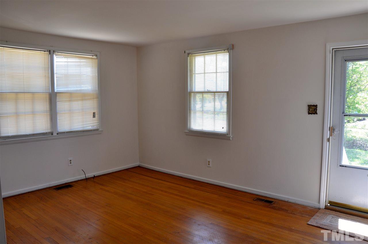 819 Hadley Road Raleigh, NC 27610 - Photo 5 of 20 an empty room with wooden floor and windows