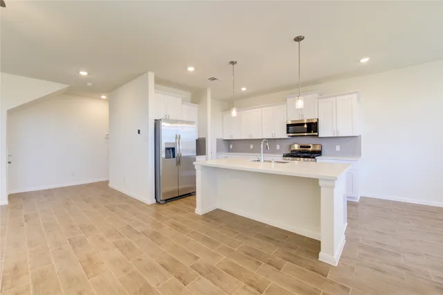 a large kitchen with a table and chairs in it