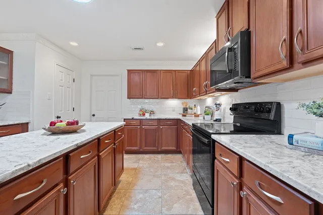 a kitchen with stainless steel appliances granite countertop a stove a sink and a refrigerator